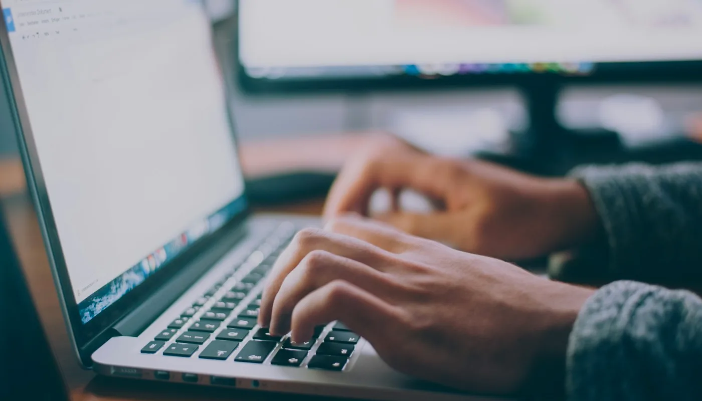 Digital creator analyzing real-time search trends and structuring digital PDF guides on dual monitors